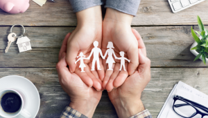 Hands holding a cutout of a family